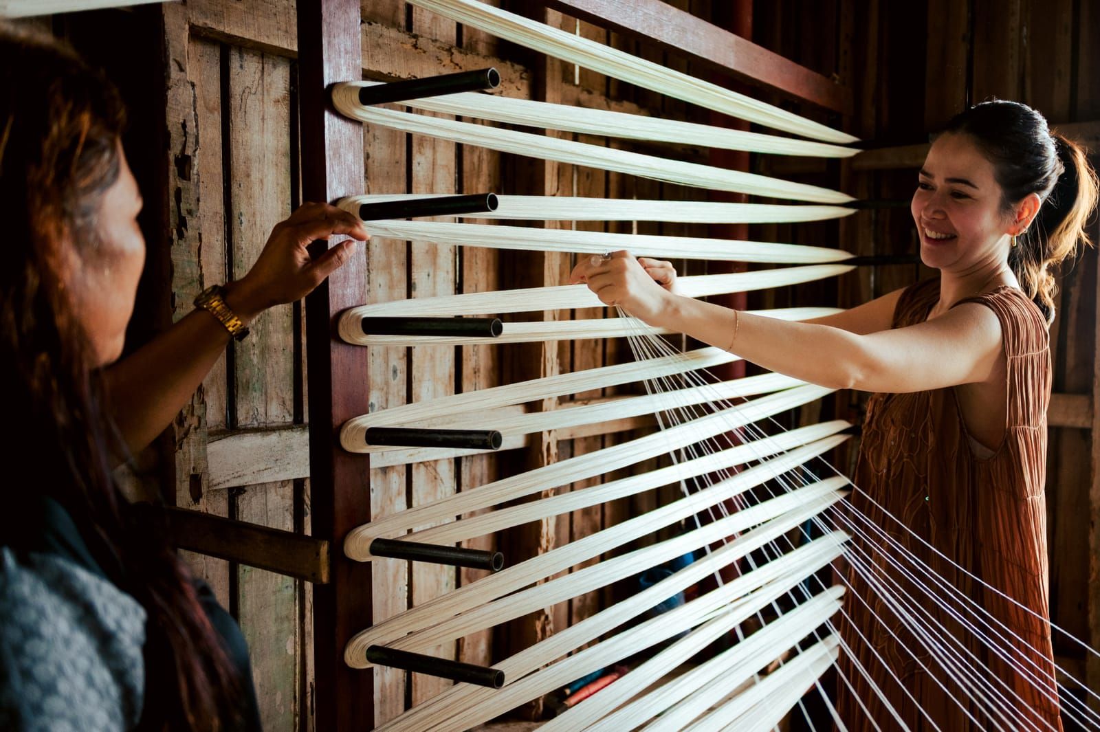 Bela Padilla laughing as she warps threads with a weaver