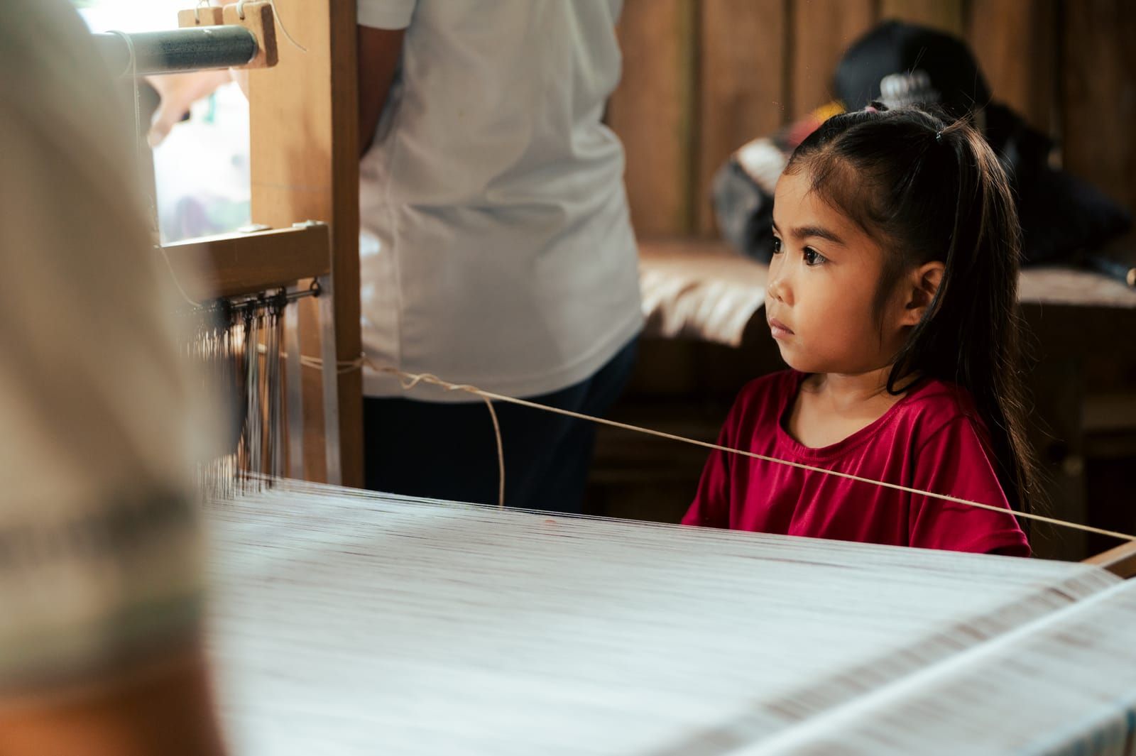 A young girl watching the weaving