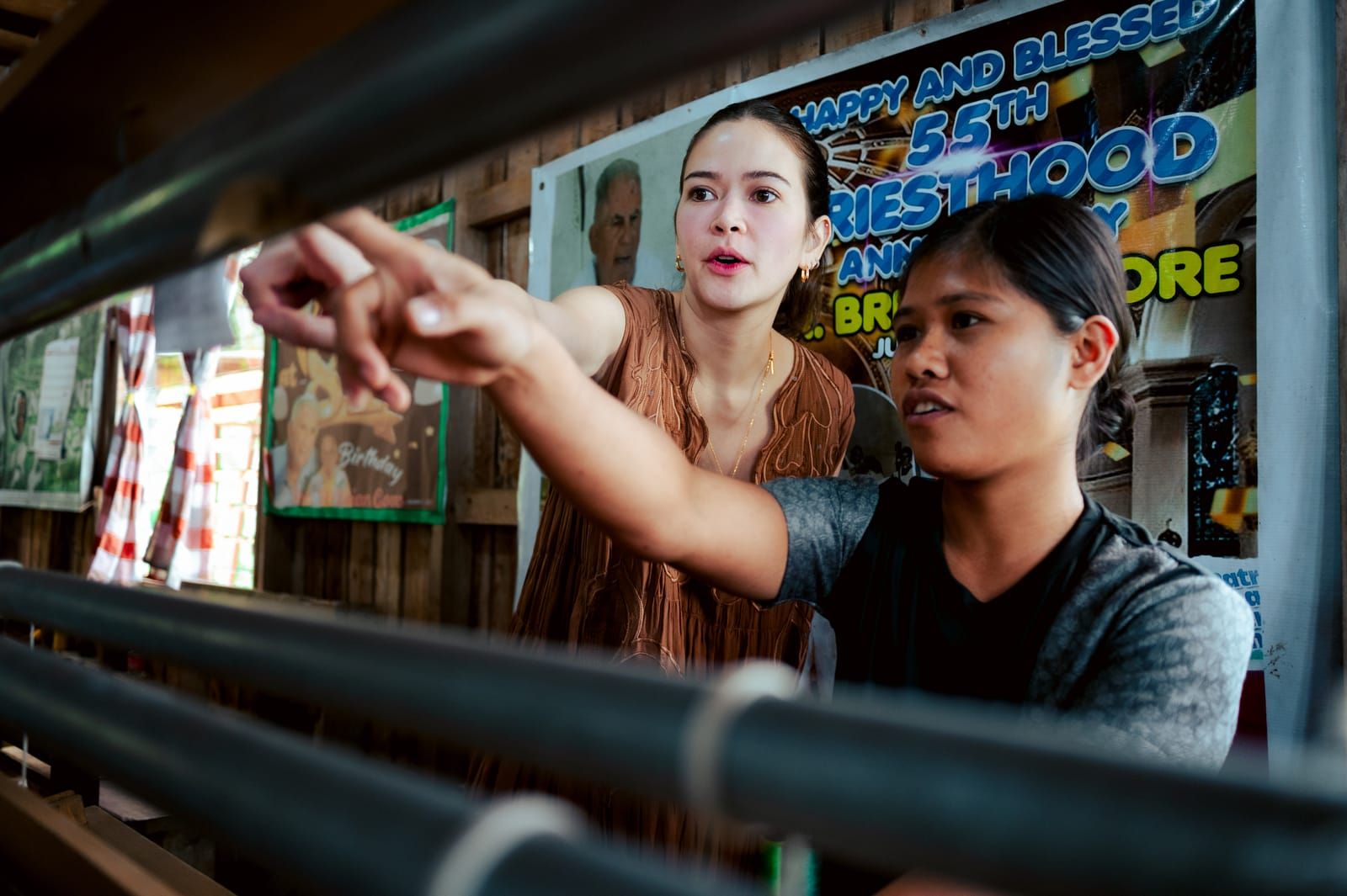 A weaver showing Bela Padilla how the loom works