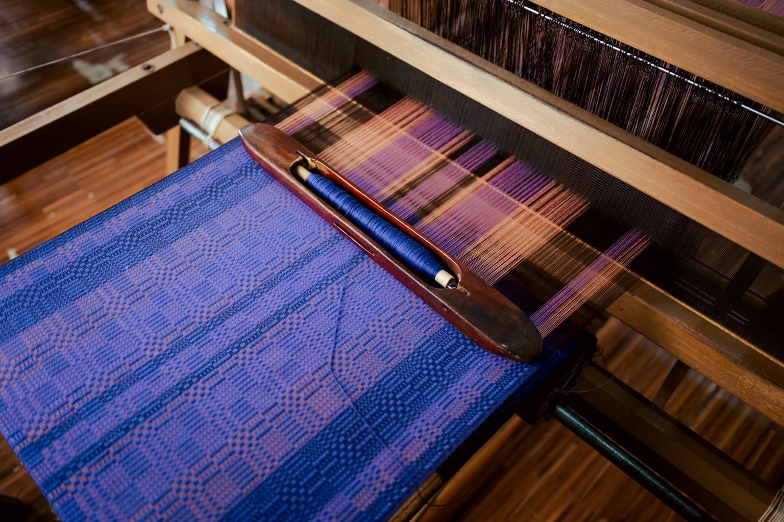 Purple handwoven fabric on the loom