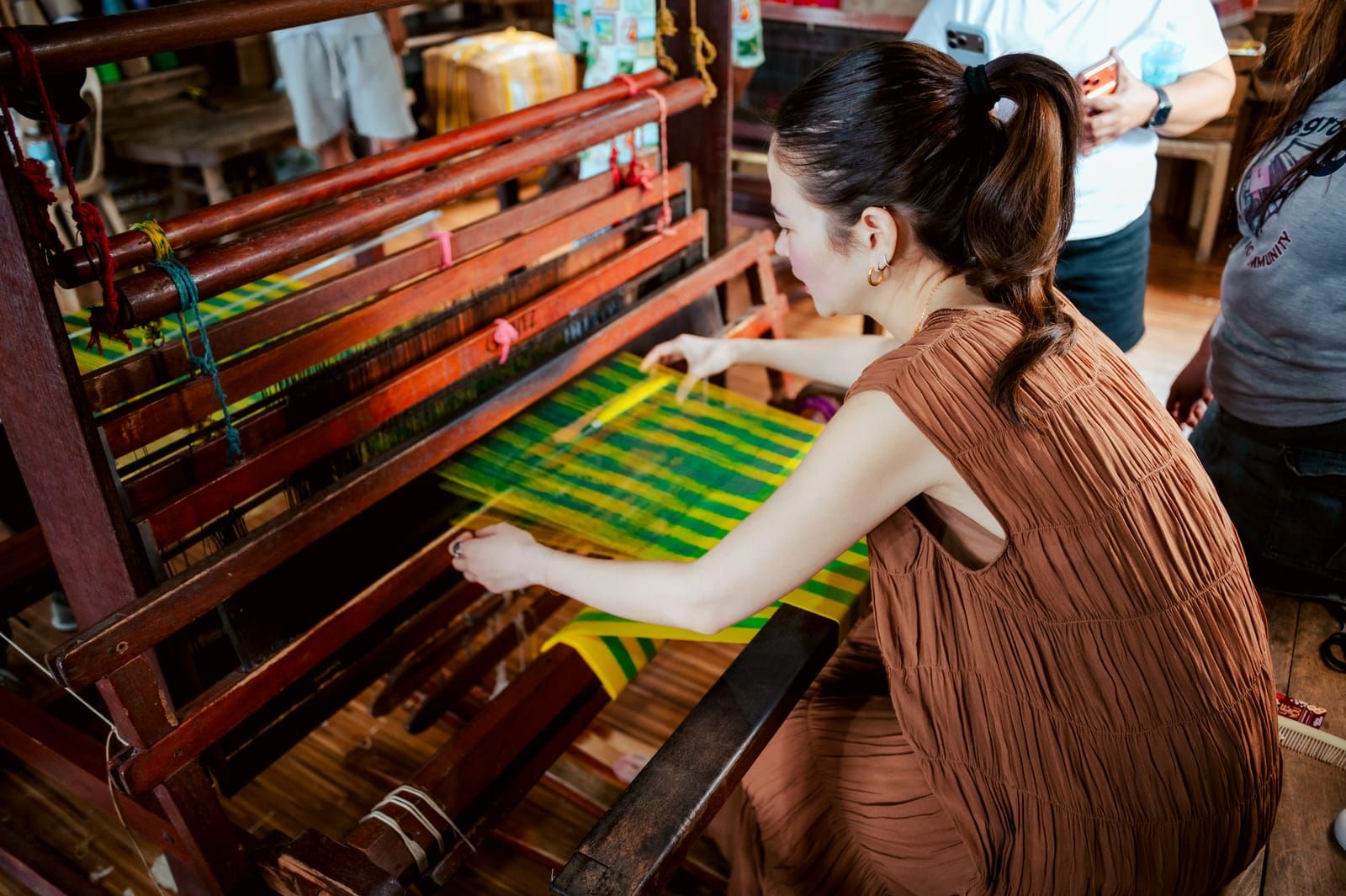 Bela Padilla weaving at a wooden loom