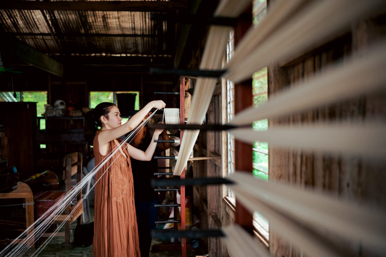 Bela Padilla warping threads in the weaving centre