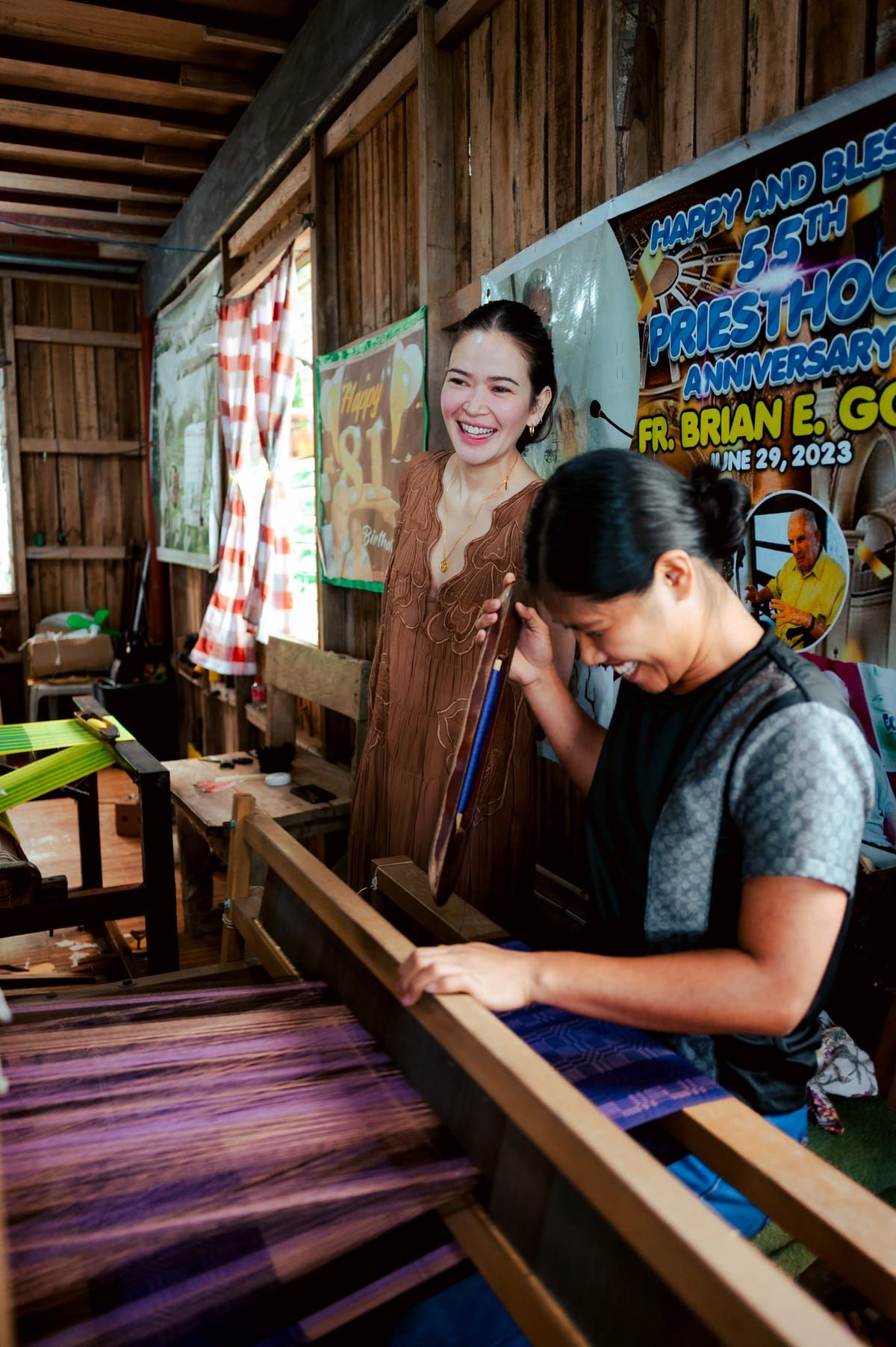 Bela Padilla and a weaver at a loom with purple threads