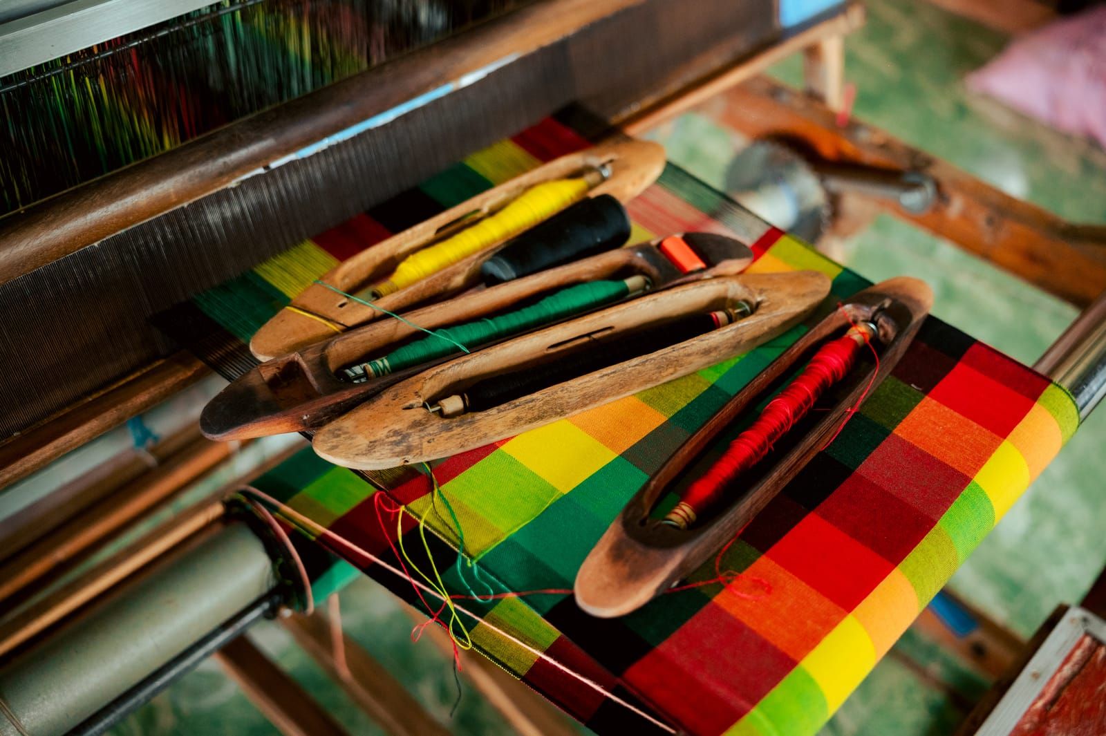 Shuttles resting on colourful handwoven cloth