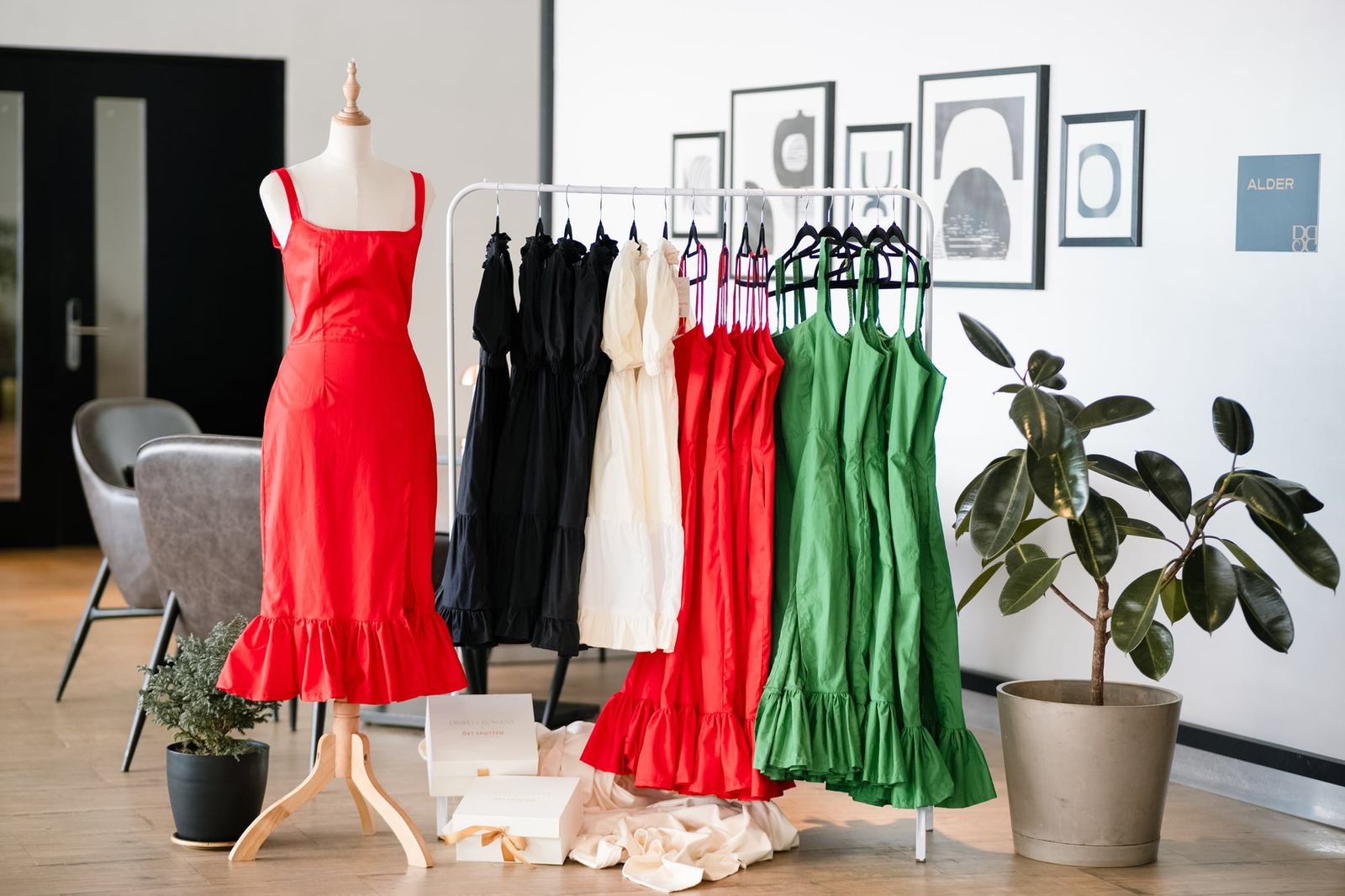 Red, black, white and green dresses from the Dimples Romana collection on a rack and a mannequin