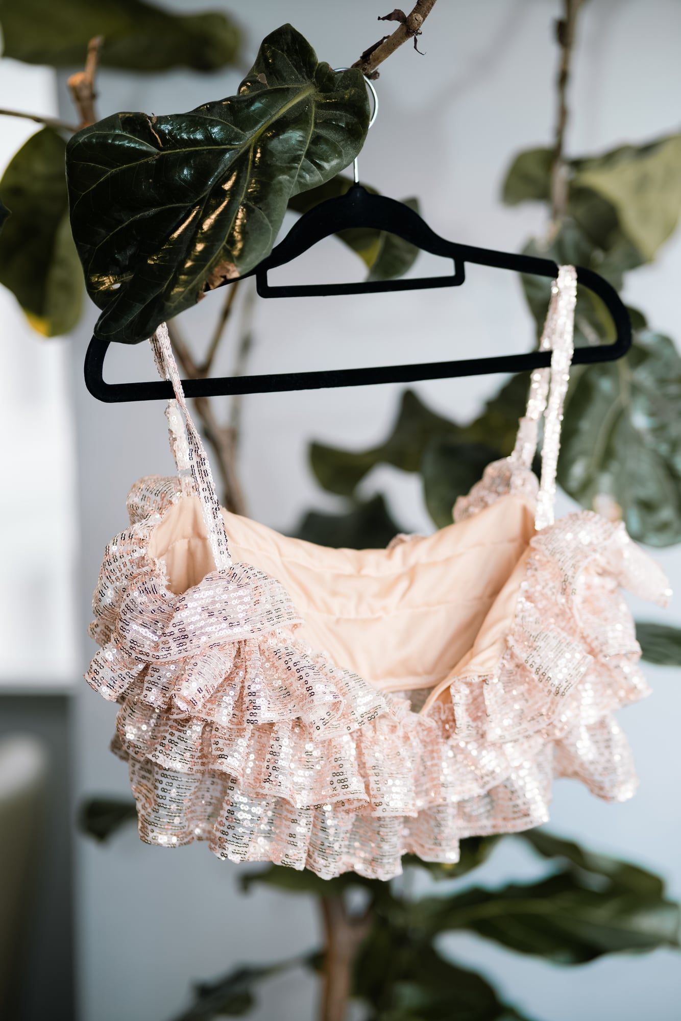 A frilly blush top from the collection hanging among the plants