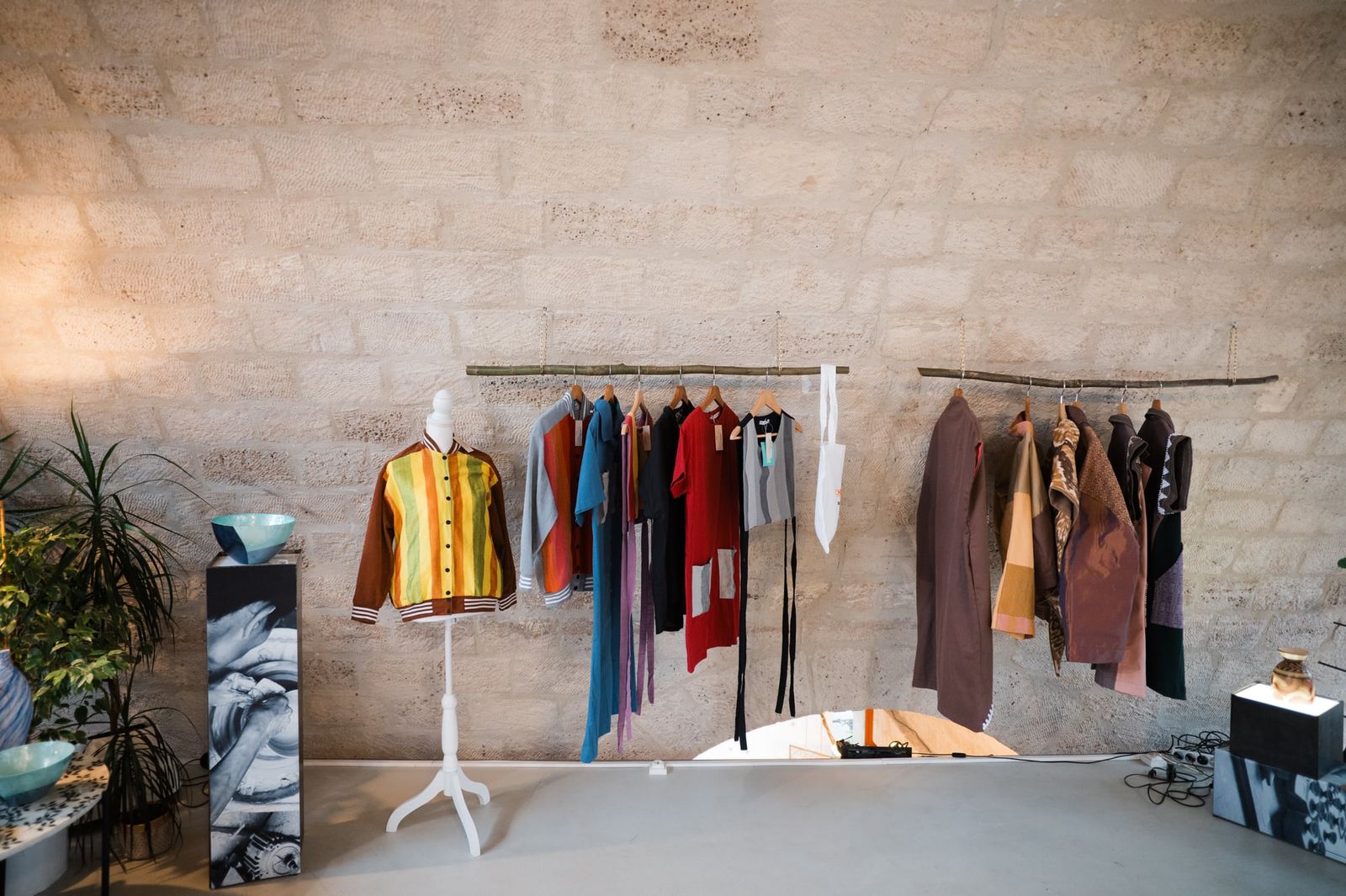The full CHICKS x Get Spotted display along the stone wall of the Paris showroom