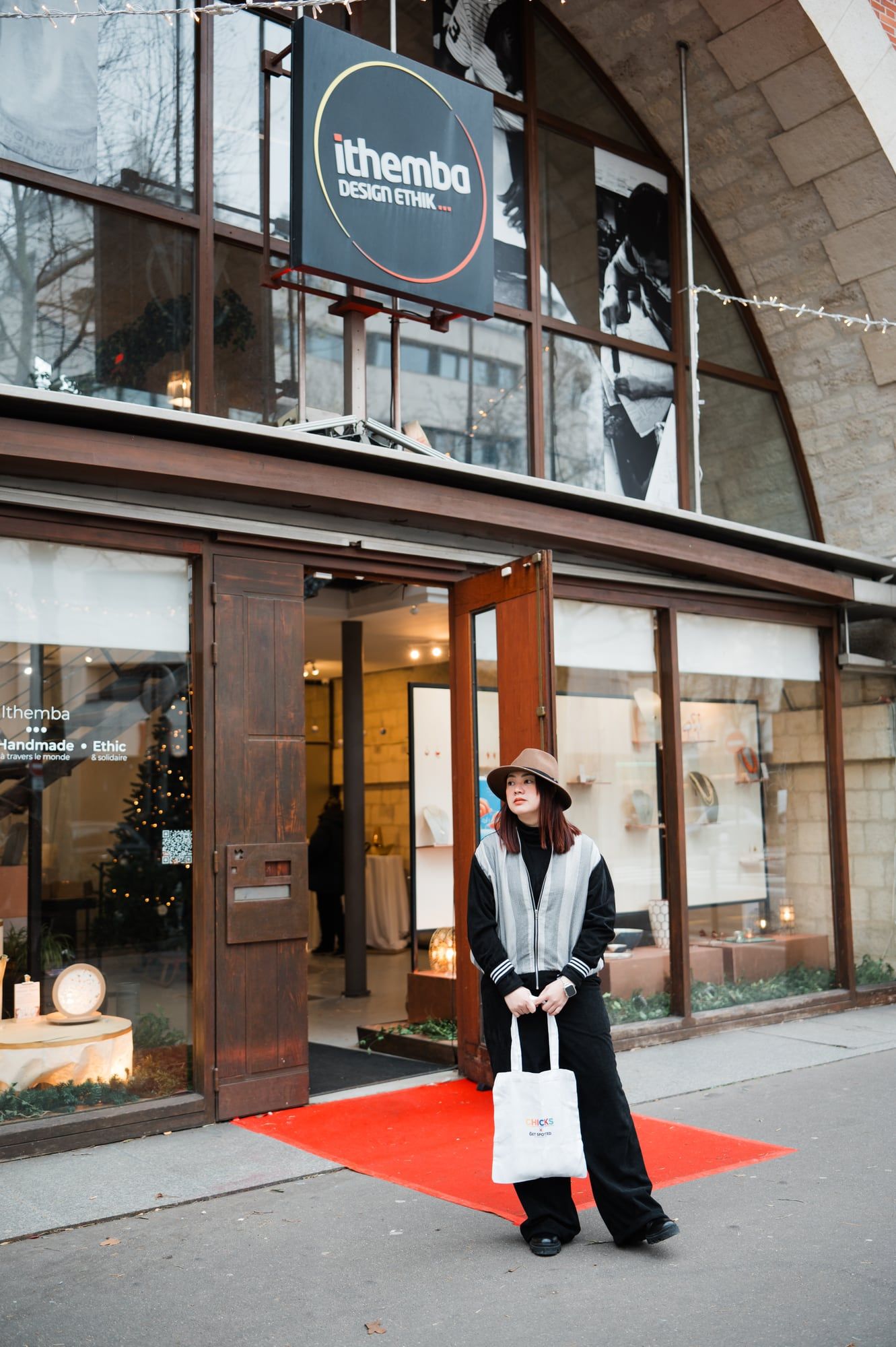 Emgee outside the Ithemba showroom at the Viaduc des Arts, holding a CHICKS tote