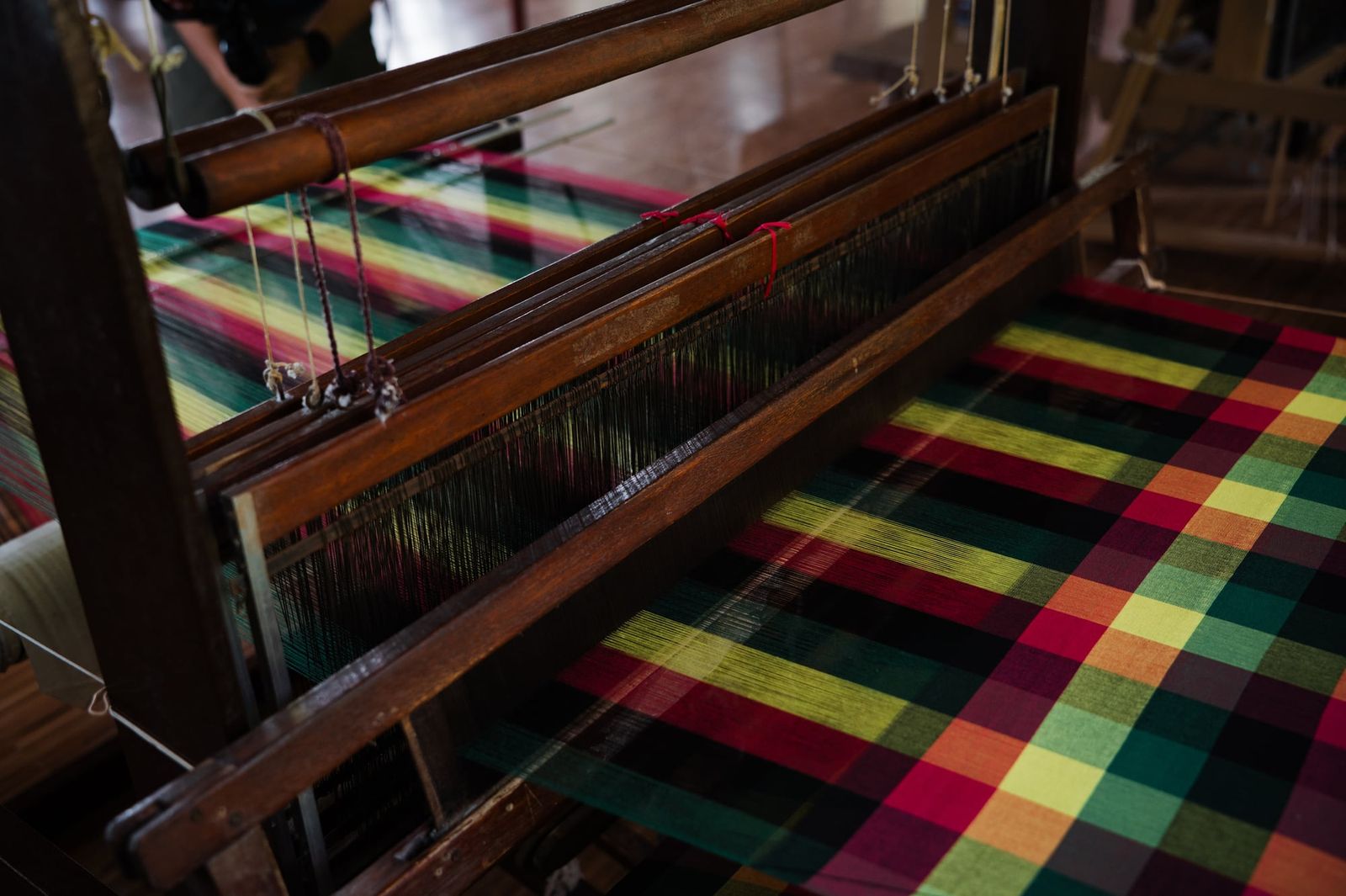 Bright plaid hablon taking shape on a handloom