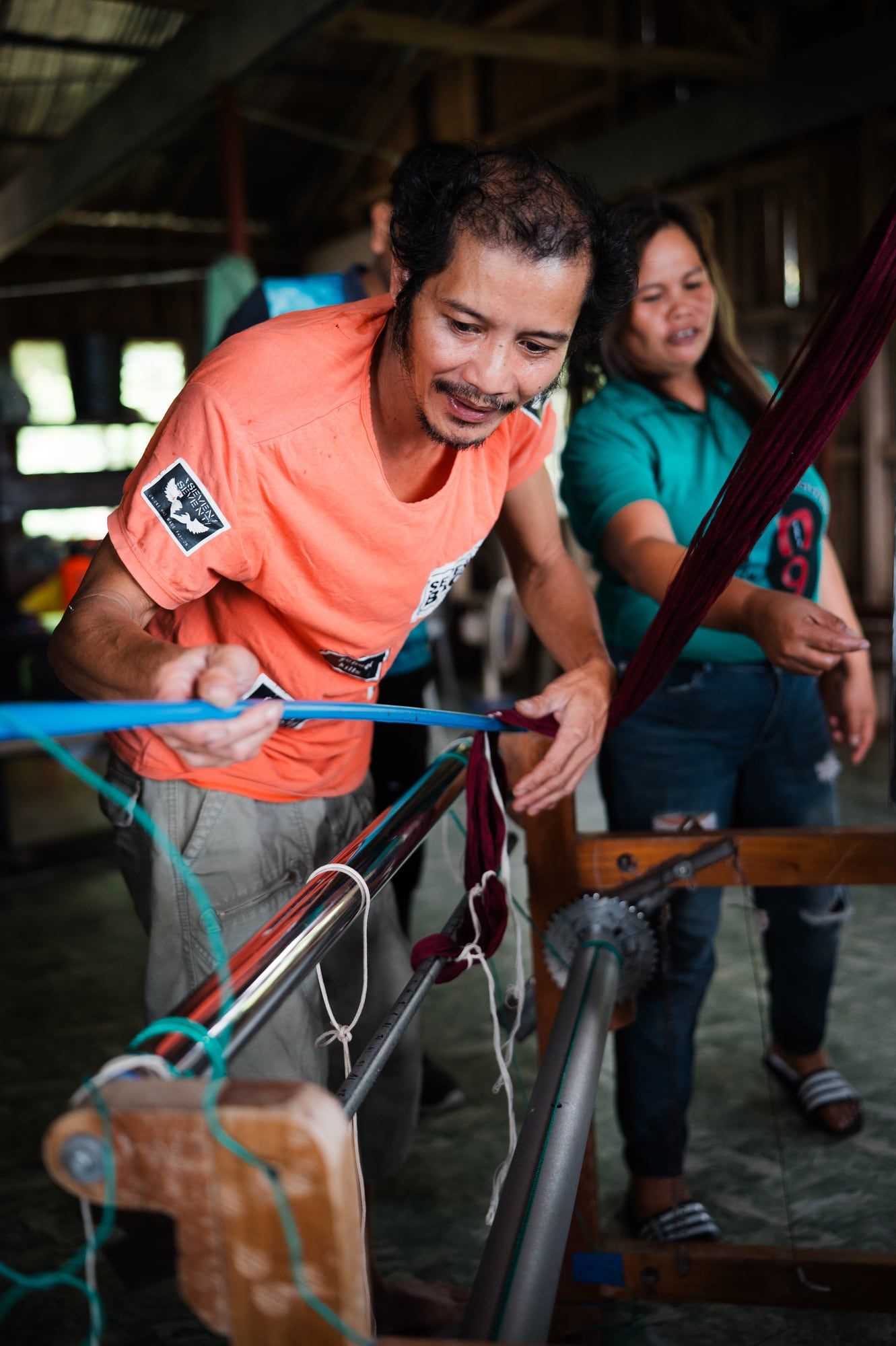 Two weavers setting up the warp on a loom