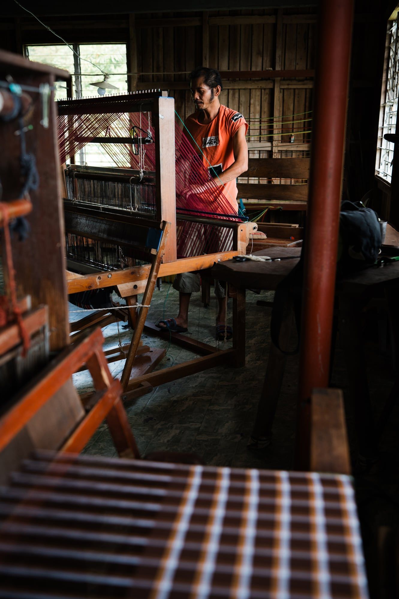 A weaver at work on a handloom inside the Negros 9 weaving centre
