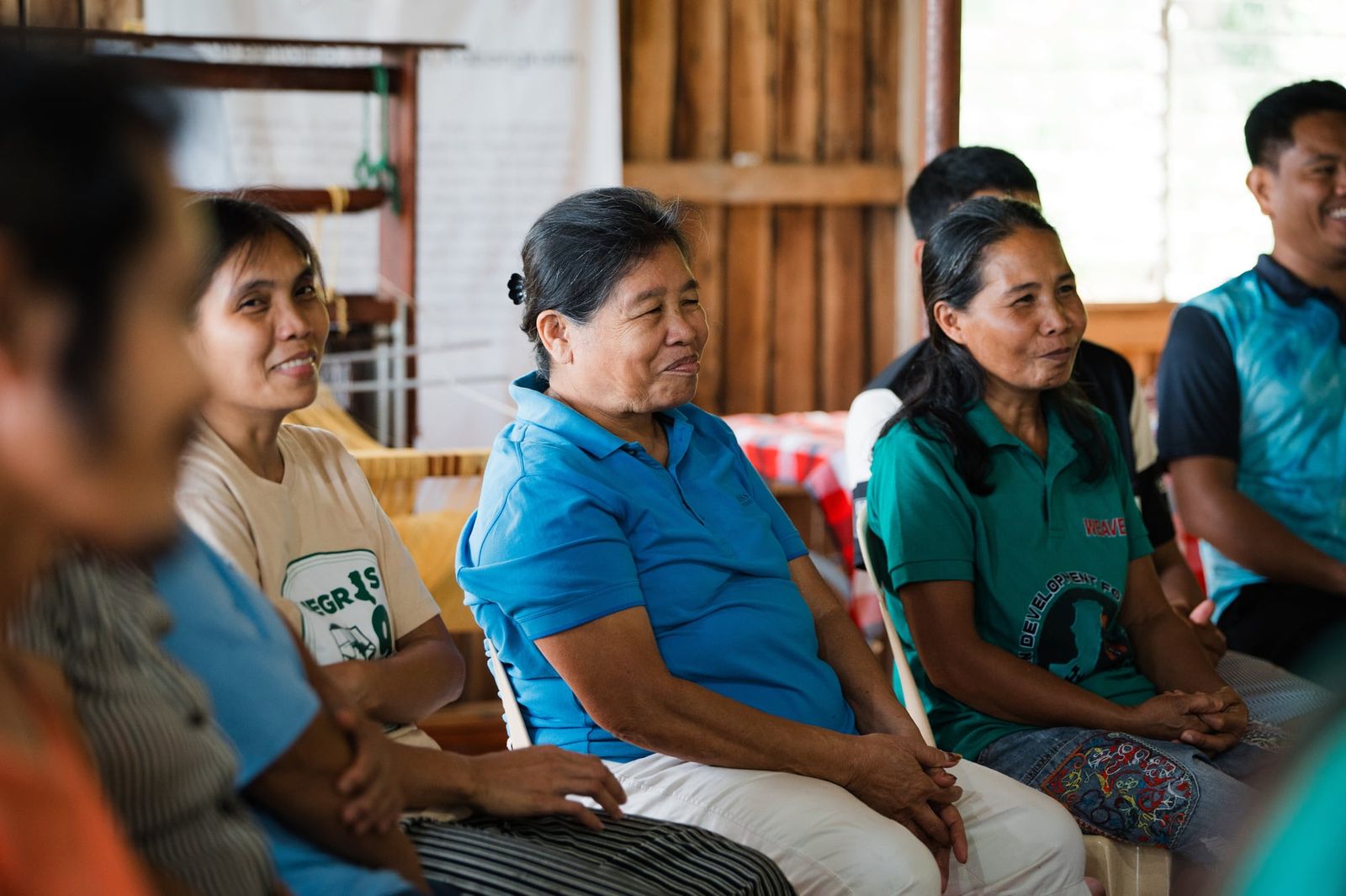 Weavers listening and smiling during the visit