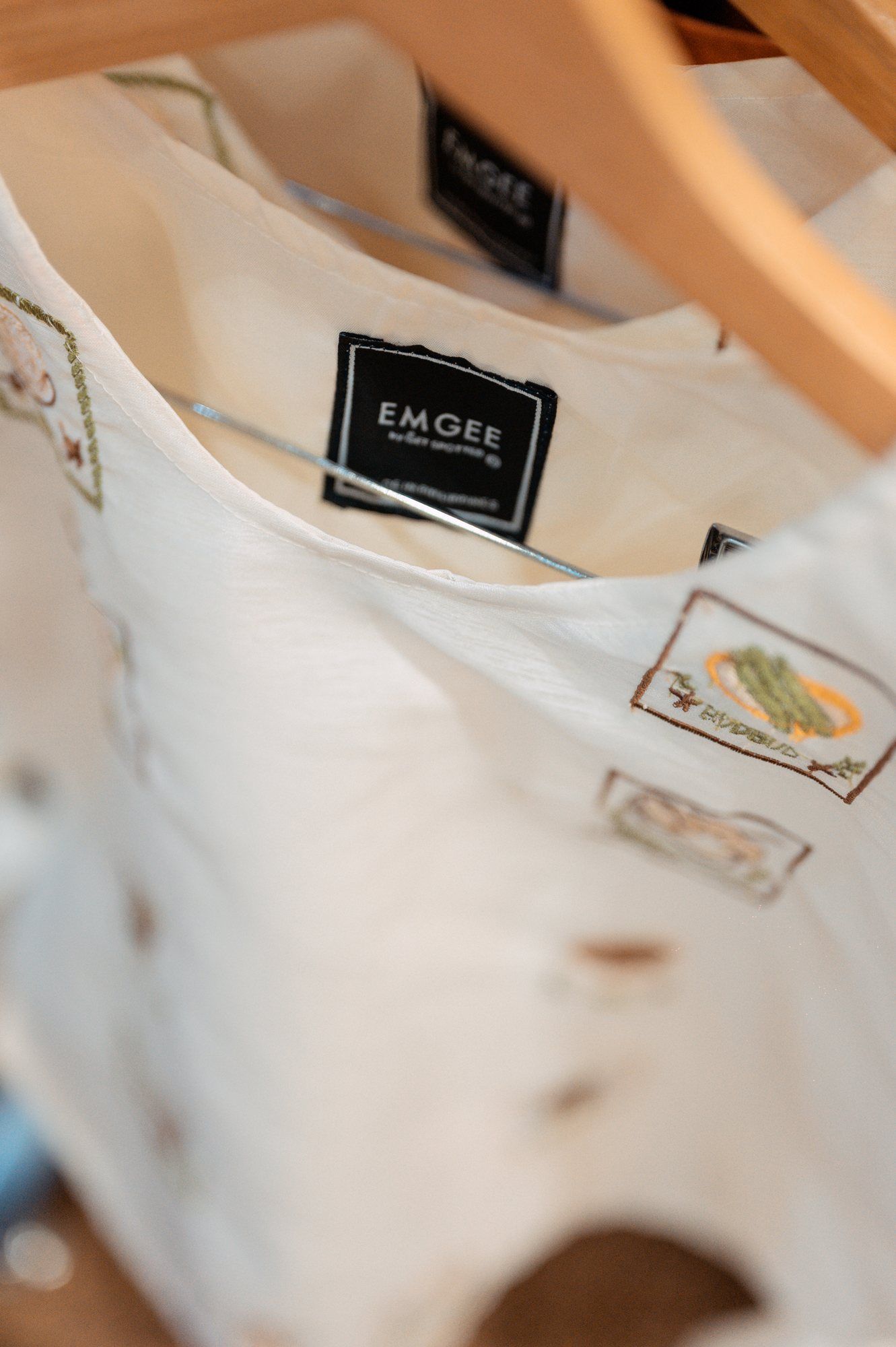 EMGEE by Get Spotted label on a white top with embroidered patch